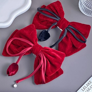 Detail of red velvet bow hair clips with hanging tulip pendants and pearl accents