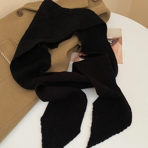 Close-up of black ribbed knit scarf texture on khaki coat with a cozy winter vibe