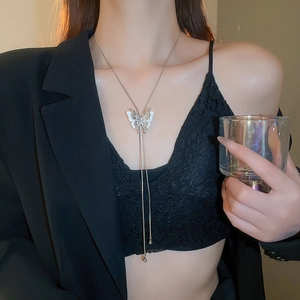 Detail of silver butterfly pendant necklace with elegant tassels on female model