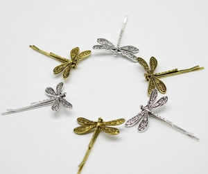 Macro detail of retro dragonfly hair clips in silver and bronze metal with hollow wings