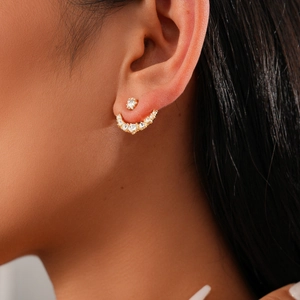Detailed view of elegant gold star and moon jacket earrings worn by a model