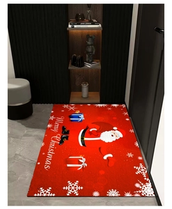 Gros plan d'un paillasson Joyeux Noël rouge avec Père Noël et boîtes de cadeaux