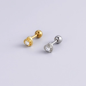 Close-up of gold and silver heart-shaped ear studs with sparkling cubic zirconia stones