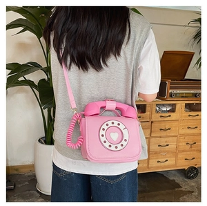 Back view of the pink retro telephone crossbody bag with heart dial design details