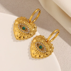 Close-up of gold plated heart earrings with malachite evil eye and sparkling crystals