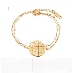 Detail view of double-layer gold stainless steel bracelet with white beads and sun pendant