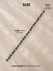 Close-up of bridal crystal belt with green rhinestones and white ribbon dimensions