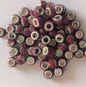 Macro shot of red clay beads with inlaid rhinestones and large 5mm metal eyelet holes