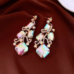 Close-up of gold drop earrings with aurora borealis crystals on dark red silk