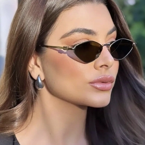 Retro geometric sunglasses with dark lenses and gold metal frames on a model outdoors