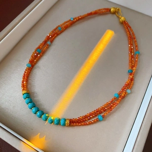 Three-layer beaded necklace featuring orange beads, turquoise accents and golden spacers