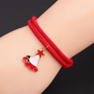Detail of red braided Christmas bracelet with enamel Santa hat charm on wrist