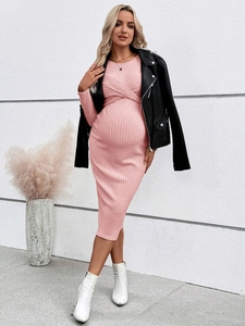 Detailed texture of pink ribbed knit maternity dress with slim fit and vertical stripes