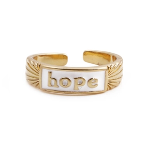 Close-up of golden adjustable ring featuring white enamel and engraved HOPE lettering