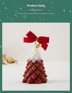 Detail of a Christmas tree candle with red white layers and a red bow with a golden bell