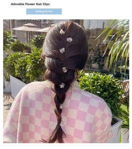 Mini floral hair clips styled on braided hair with pearls and acrylic details