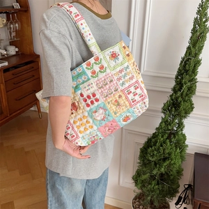 Quilted cotton patchwork tote bag shown on model in a cozy vintage home setting