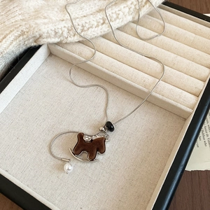 Detail of flocked pony pendant on silver snake chain with pearl and black bead accents