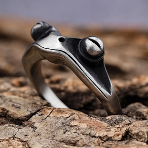 Macro shot of vintage silver frog ring with detailed skin texture on tree bark