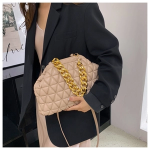Beige quilted leather handbag with gold chain strap shown on a professional model