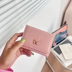 Pink trifold short wallet with gold butterfly metal hardware and heart zipper pull