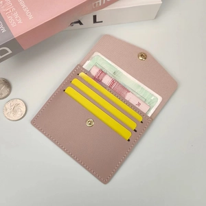 Detail of pink faux leather card holder with litchi texture and snap button closure