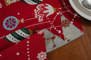 Close-up of woven jacquard Christmas table runner showing Santa Claus patterns and texture