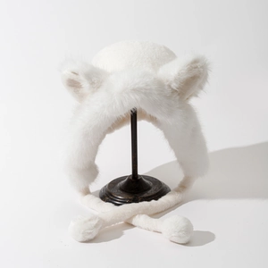 Detail of white faux fur winter hat with fox ears and fluffy pom-pom earflaps
