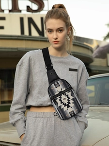 Detail of bohemian geometric pattern crossbody bag with multiple zippers and fabric strap
