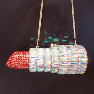 Macro detail of luxury lipstick-shaped clutch bag with red and silver shimmering crystals