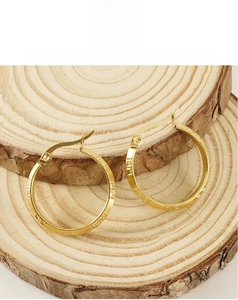Macro view of 18K gold-plated stainless steel hoop earrings with Greek key pattern detail