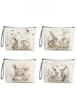 Detail of four canvas toiletry bags featuring watercolor bunny prints and black zippers