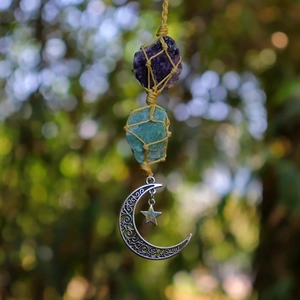 Detail of woven rope pouch holding amethyst and turquoise crystals with star moon charms