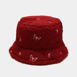 Detailed view of white butterfly embroidery on burgundy faux shearling bucket hat