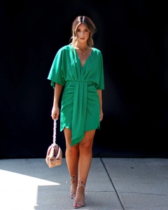 Détail de la robe mini verte avec décolleté en V plongeant et lien de taille drapé élégant