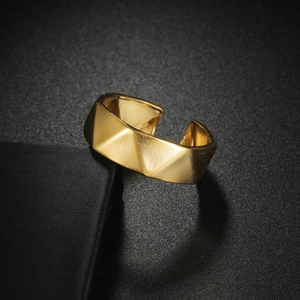 Golden faceted stainless steel open ring with geometric design on black fabric