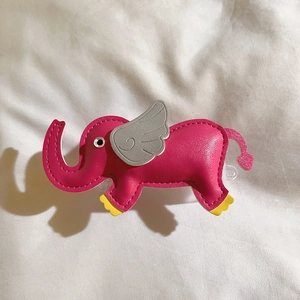 Pink faux leather elephant phone accessory with grey wings on white fabric