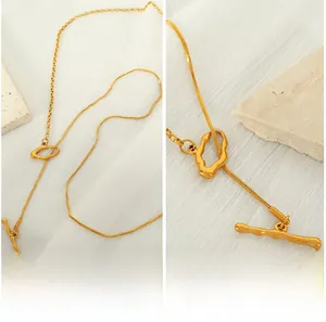 Macro detail of irregular lava-textured gold ring and OT buckle on sleek snake chain