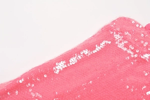 Macro shot of pink sequins and delicate ruffle details on an elegant evening gown