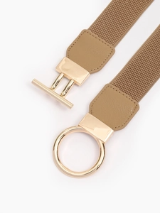 Detail of light gold metal circle and T-bar buckle on a khaki elastic stretch belt