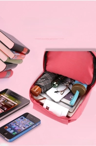 Internal view of pink travel backpack showing large capacity for umbrella and phone