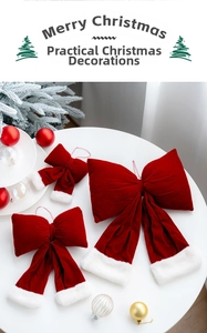 Three red velvet Christmas bows with white faux fur trim on a festive white platform