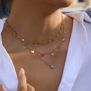 Détail du collier multicouche plaqué or 18k avec pendentifs en forme de cœur rose et ovale