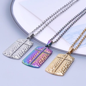 Detail of cross pendants in silver, gold, and rainbow colors with textured finish