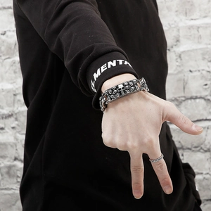 Close-up of gothic skull links on men's titanium steel bracelet with polished metal texture