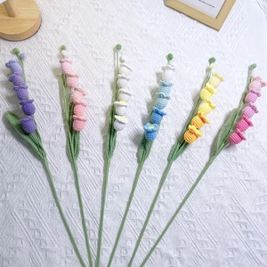 Handmade knitted lily of the valley bouquet in six vibrant colors on white knit background