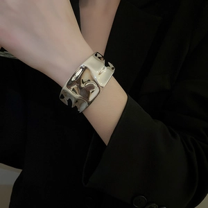 Detailed view of wide irregular silver cuff bracelet with reflective polished finish