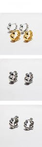 Detailed macro view of spiral twisted hoop earrings in polished gold and silver finishes