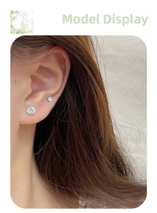Detailed close-up of sparkling cubic zirconia stud earrings set on a model ear