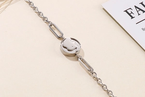 Detail of silver chain bracelet with round hollow elephant pendant and mixed links